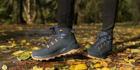 Jesienne buty trekkingowe na tle liści. Idealne, by dowiedzieć się, jak się ubrać w góry jesienią.