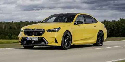 Ein gelber BMW M5 rast auf einer Straße. Die BMW M5 Farben sind leuchtend und auffällig.