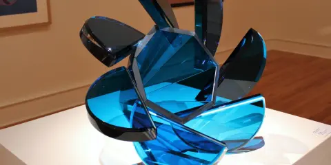 A sculpture of blue glass shards, showcasing transparency in art, with light reflecting through its facets.