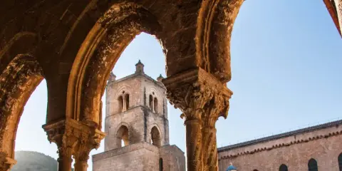 Archi decorati e campanile del Duomo di Monreale, un luogo imperdibile da vedere in Sicilia.