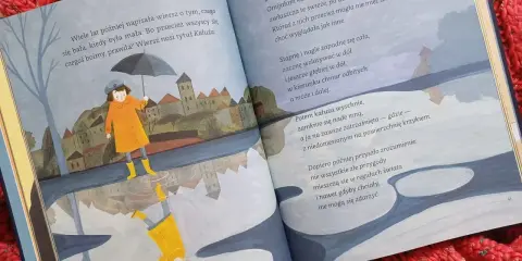 Ilustracja do krótkich wierszy Wisławy Szymborskiej. Dziewczynka w płaszczu i kaloszach z parasolką odbija się w kałuży.
