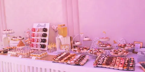 Słodki stół weselny dla 80 osób: mnóstwo ciast, babeczek i donutów.