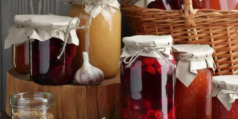 Słoiki z przetworami, gotowanie słoików na zimę. Widać buraki, dżem, czosnek i przyprawy.