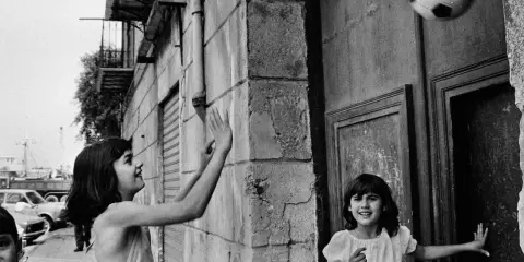 Bambine giocano a pallone in strada, un momento catturato da una fotografa famosa italiana.