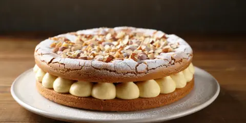 Une dacquoise, ce gâteau aérien aux amandes, garni de crème onctueuse et saupoudré de sucre glace et d'amandes concassées.