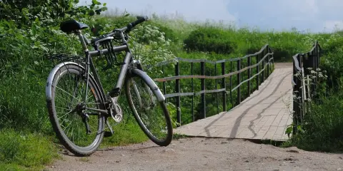Rower czeka przy moście, gotowy na dalszą podróż. Idealne miejsce na noclegi dla rowerzystów, gdzie można odpocząć po dniu pełnym wrażeń.