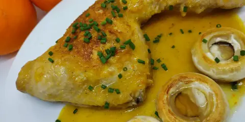 Pollo a la naranja jugoso con salsa cítrica, acompañado de champiñones y cebollino fresco.