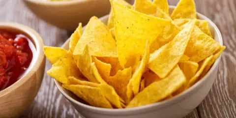 Un tazón lleno de crujientes nachos caseros, listos para ser sumergidos en salsa.