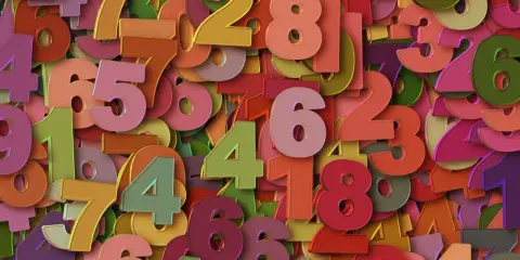 Kolorowe cyfry tworzą gęsty wzór. Wśród nich wyróżnia się liczba 2, symbolizująca rok numerologiczny 2, zachęcając do harmonii i współpracy.