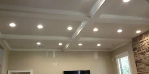 Elegancka wnęka na led w suficie z kasetonami i ozdobnymi listwami, tworząca nowoczesną aranżację wnętrza.