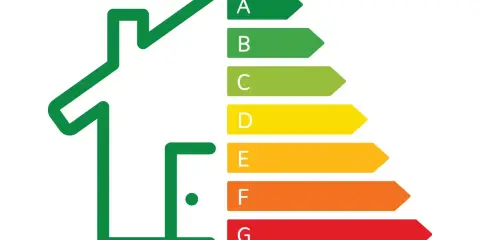Casa stilizzata con scala di efficienza energetica (A-G). La certificazione energetica cos'è? Indica l'efficienza di un immobile.