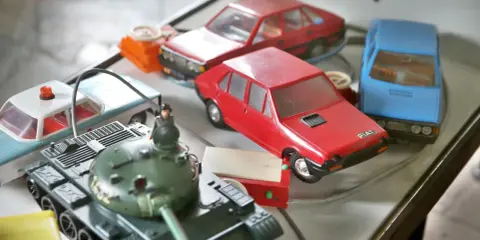 Kolekcja **polskich zabawek**: czołg, radiowóz, czerwony Fiat i niebieski samochód.