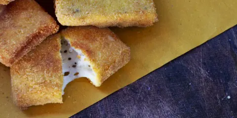 Mozzarella in carrozza dorata e croccante, con il formaggio filante che fuoriesce da uno spicchio.