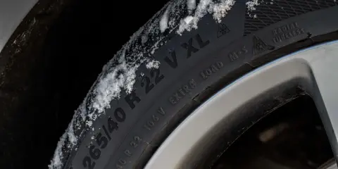 Pneumatici M+S con neve sul battistrada, pronti per affrontare l'inverno.