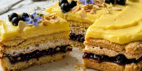 Oryginalny mazurek wielkanocny z kremem cytrynowym, czarnymi porzeczkami, bezą i płatkami migdałów.