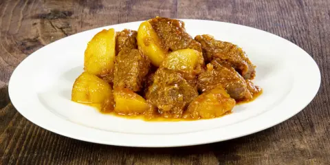 Spezzatino con patate, la ricetta della nonna che scalda il cuore. Morbidi pezzi di carne e patate dorate in un sugo saporito.