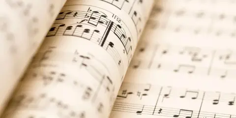 Partitions musicales ouvertes, révélant les nuances de la musique. Les notes et les portées se déploient, invitant à l'interprétation.