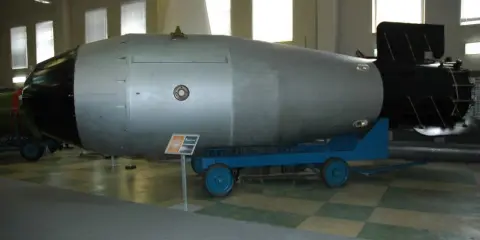 Ogromna bomba atomowa na wózku, symbol potęgi i potencjalnego zasięgu fali uderzeniowej bomby atomowej.
