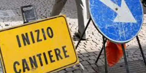 Segnale giallo "Inizio cantiere" e segnale blu con freccia a destra indicano lavori in corso.