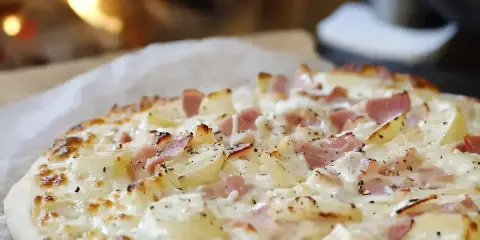 Flammekueche ou flamenkuch, une tarte fine garnie de lardons, de pommes de terre et de crème, cuite au feu de bois.