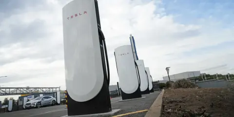 Stazione di ricarica Tesla Supercharger, con una Tesla in carica. Il costo del servizio è un fattore importante per i proprietari.