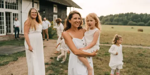 Rodzina w białych strojach, radość i spokój. To może być piękny ślub bez wesela, z bliskimi w rustykalnym otoczeniu.