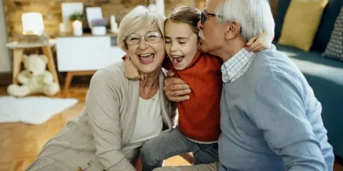 Nonna e nonno abbracciano felici la nipote. Un momento di gioia che sottolinea il diritto dei nonni a vedere i nipoti, un legame prezioso.