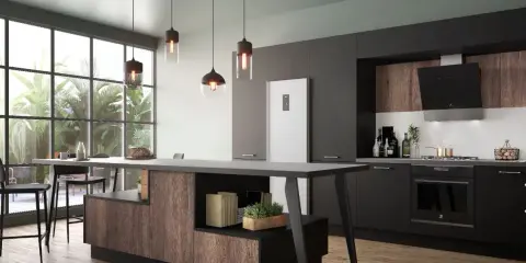Cuisine fermée avec coin repas moderne, îlot central en bois et noir, réfrigérateur blanc, et grandes fenêtres donnant sur la verdure.