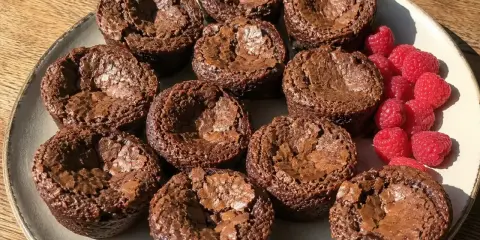 En tallrik med kladdkakemuffins och hallon. Perfekt för ett kladdkakemuffins recept!