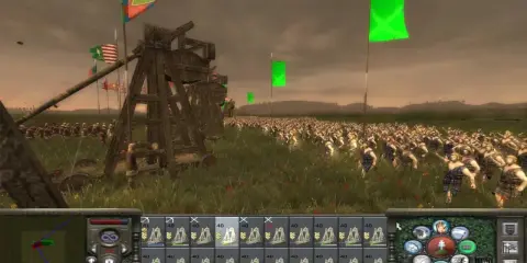 Bitwa w grze strategicznej, przypominającej gry podobne do Total War. Ogromna armia w starożytnych strojach, machiny oblężnicze i flagi na tle pochmurnego nieba.
