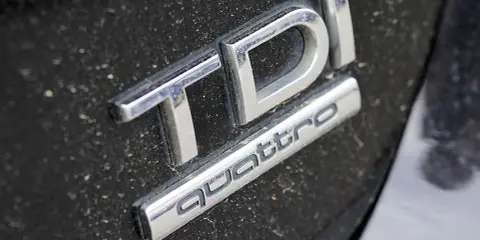 Emblemat TDI Quattro na zakurzonej czarnej karoserii. Zastanawiasz się, 2.0 tdi ile oleju potrzeba?