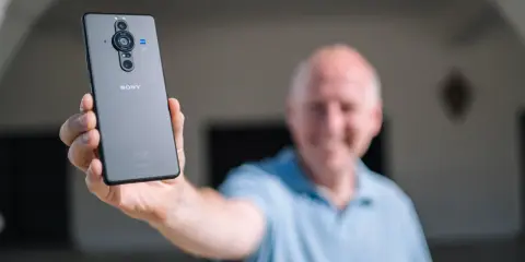 Mężczyzna prezentuje tył telefonu Sony Xperia Pro z potrójnym aparatem.