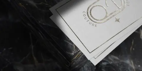 Eleganckie, kreatywne wizytówki z logo "Eva Dados Couture" na tle luksusowego marmuru.