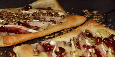Ciasto francuskie z camembertem, gruszką i żurawiną, posypane słonecznikiem.