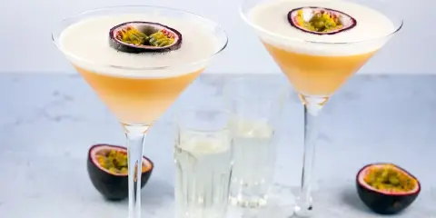 Dwa drinki Pornstar Martini, ozdobione połówką marakui, z kieliszkami z dodatkowym shotem. Idealne, by dowiedzieć się, jak pić.