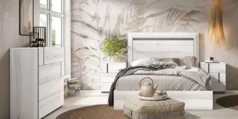 Dormitorio moderno con cabecero de cama en blanco veteado, papel tapiz botánico y cómoda a juego. Un diseño que evoca la calma del feng shui.