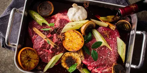 Råstekta köttbitar med apelsin, lök, vitlök och stjärnanis i en form. Ett perfekt minutfile recept för en festmåltid.
