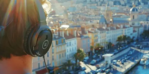 Personne avec des écouteurs, profitant de la musique persane face à une ville ensoleillée.