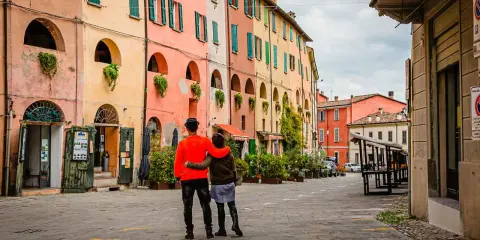Coppia abbracciata in una strada con case colorate, un assaggio dei paesi belli vicino Ravenna.