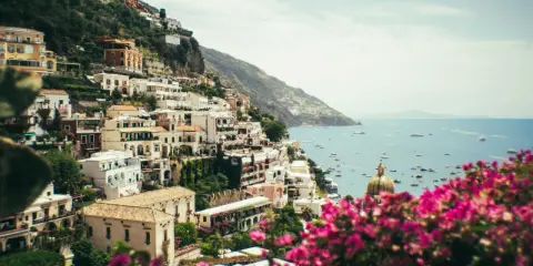 Positano, uno dei paesi più belli della Costiera Amalfitana, con case bianche aggrappate alla scogliera e il mare blu pieno di barche.