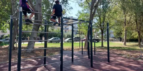 Bambini si arrampicano su una struttura per esercizi all'aperto nel parco Briolini a Rimini.