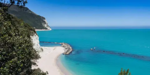 Spiagge piu belle d'Italia: una caletta di sabbia bianca incastonata tra scogliere a picco e un mare turchese cristallino.