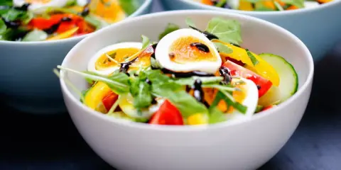 Sałatka z jajkiem, pomidorem, ogórkiem i rukolą, bogata w **błonnik**. Polewana sosem balsamicznym.
