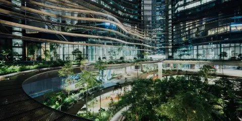 Ein atemberaubendes Beispiel für innovative Architektur: geschwungene Ebenen mit üppiger Vegetation, die sich durch ein modernes Gebäude schlängeln.