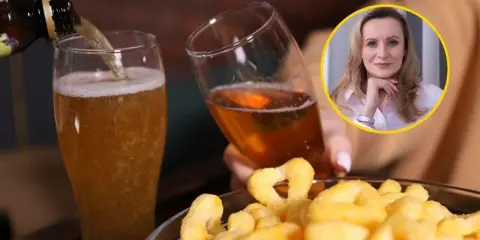 Kobieta z piwem i przekąskami. Alkohol, co wypłukuje magnez, może prowadzić do problemów zdrowotnych.
