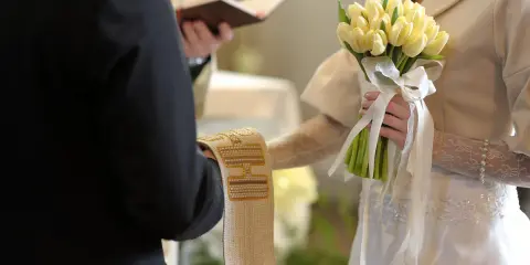 Para młoda trzyma bukiet żółtych tulipanów. Ceremonia ślubna, czy w adwencie można robić wesele?