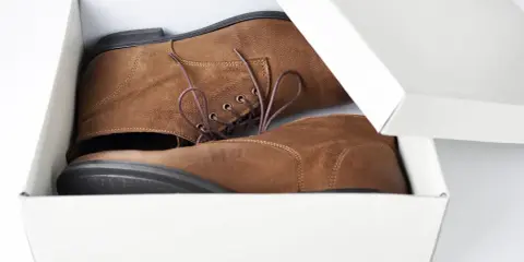 Brązowe buty w pudełku, gotowe do wysyłki. Dowiedz się, jak zapakować buty do wysyłki, by dotarły bezpiecznie.