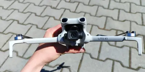 Ręka trzyma najnowszy dron DJI, gotowy do lotu. Jego kompaktowa konstrukcja i zaawansowana kamera zapowiadają niesamowite ujęcia.