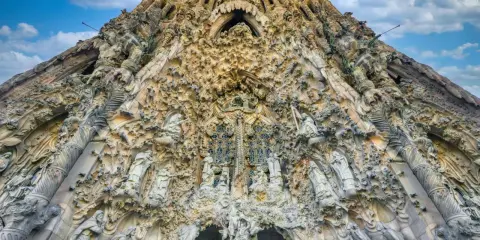 La Sagrada Familia, un capolavoro architettonico, si erge maestosa. La sua facciata è un tripudio di sculture, un racconto visivo che si estende dalla **distanza porto Barcellona Sagrada Familia**.