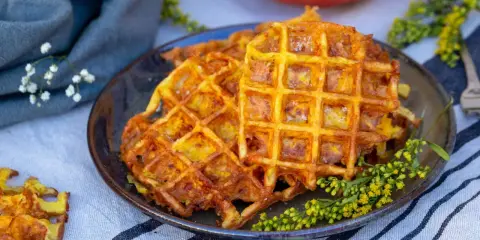 Gaufres dorées et croustillantes, une délicieuse gaufre potimarron salé, garnie de petites fleurs jaunes.